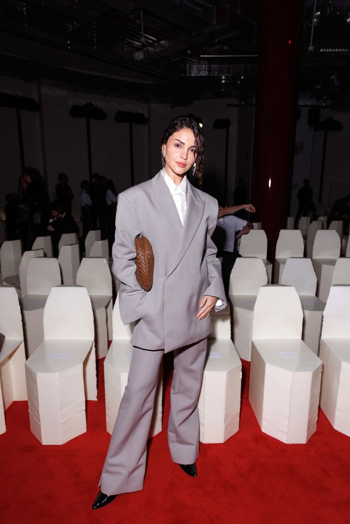 Eiza Gonzalez unjuk gaya power dressing saat hadiri peragaan busana Bottega Veneta. Setelan jas abu-abu dari rumah mode tersebut berpotongan rileks, memadukan oversized blazer dan celana flare yang tailored./ Foto: Dok. Bottega Veneta