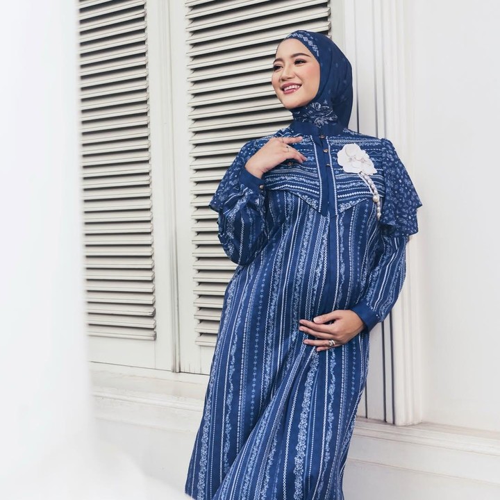 <p>Artis cantik Erica Putri saat ini tengah menjalani kehamilan keduanya yang sudah memasuki trimester akhir. Belum lama ini, Erica membagikan potret <em>outfit</em>-nya yang cocok dikenakan saat hari Lebaran. Erica mengenakan baju terusan berwarna biru dongker dengan motif bunga bergaris putih. Kakak artis Citra Kirana ini mengenakan jilbab berwarna senada dengan bajunya. Erica juga menambahkan aksesoris bunga putih di bagian atas baju. (Foto: Instagram @ericaputrii)</p>