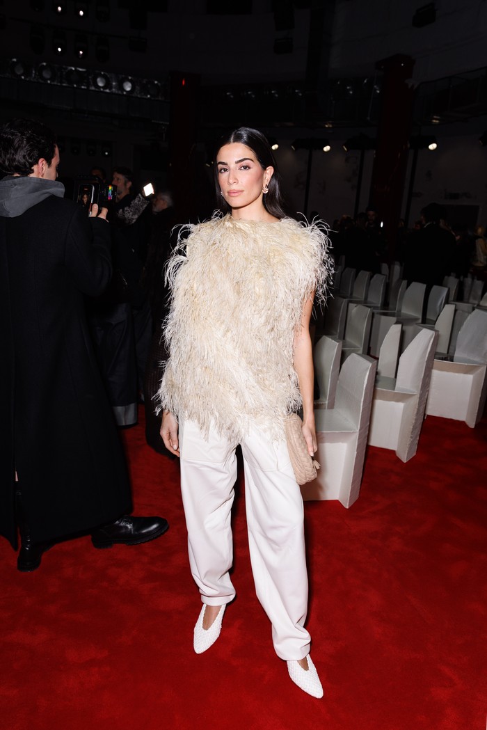 Meski tampak simple, gaya Saja Kilani memukau berkat atasan dramatis. Aktris berdarah Palestina itu memakai atasan sleeveless yang dipenuhi aksen fur yang senada dengan clutch dalam genggaman. Tampilan tersebut tetap&nbsp;lembut lewat palet warna yang netral/ Foto: Dok. Bottega Veneta