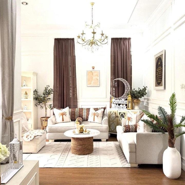 <p>Kalau kita melihat ke ruang tamunya, Natalie mengubah sofa putih polosnya dengan menambahkan sofa <em>cover</em> dan bantal bermotif pohon kurma. Di pojok kanan, terlihat dekorasi bertuliskan "Ramadhan Mubarak" lengkap dengan bulan besar sebagai hiasan. Beberapa pot tanaman hijau juga ditempatkan di sudut ruangan. (Foto: Instagram @natalie_sarahs)</p>