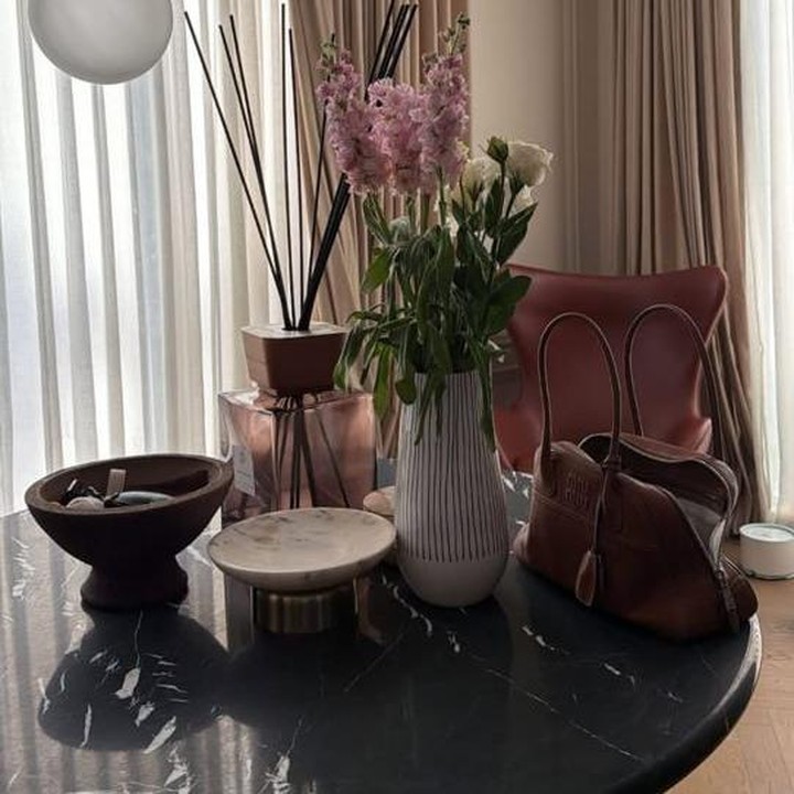 <p>Raisa meletakkan meja keramik marble modern hitam dengan desain unik di tengah ruangan, Bunda. Meja yang berisi vas bunga dan <em>reed diffuser aromatherapy</em> ini digunakan sang penyanyi untuk meletakkan barang-barang kecil, seperti tas. (Foto: Instagram @raisa6690)</p>