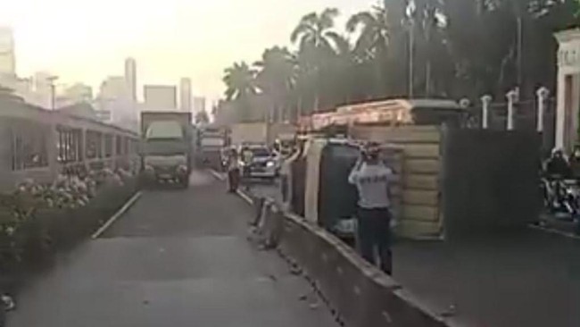 Sebuah truk terguling di Jalan Gatot Subroto depan Gedung DPR/MPR, Jakarta. Arus lalu lintas padat dan jalan licin imbas solar tumpah.