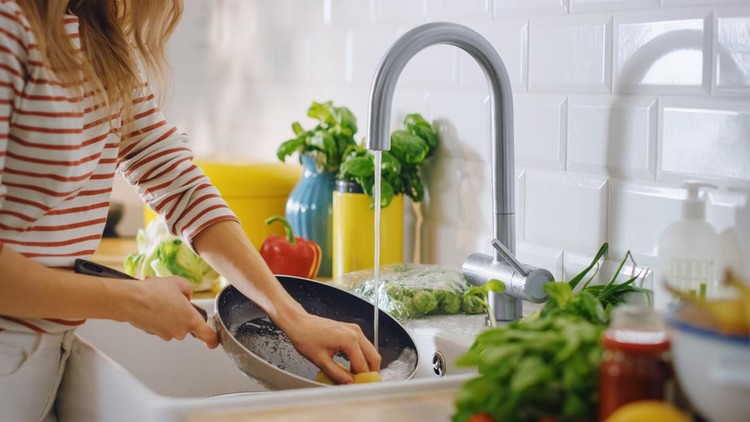 Close Up Shot of a Woman Washing a Frying Pan with a Cleaning Liquid Under Tap Water&period; Using Dishwasher in a Modern Kitchen&period; Natural Clean Diet and Healthy Way of Life Concept&period;