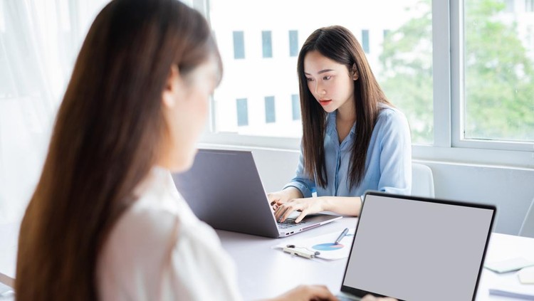 Two young Asian woman are focused on working