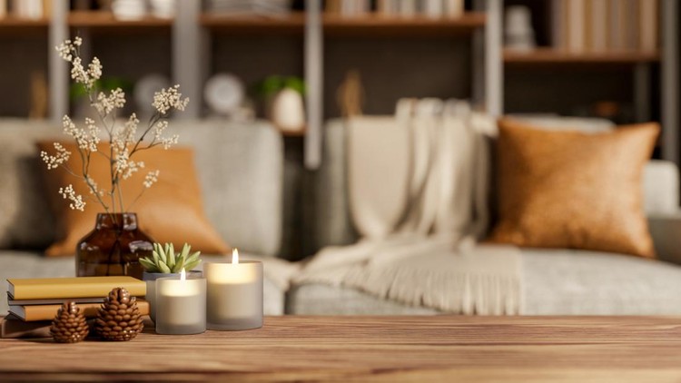 Lighting aroma scented candles and decorative item on wooden table across fabric sofa in living room&period; Calm and Soothing&comma; Product Display&comma; Cosy Atmosphere&period;