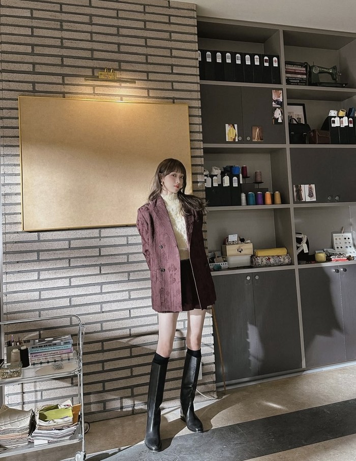 Menggunakan halter neck kuning dengan aksen fur yang dikombinasikan dengan oversize blazer dengan skort berwarna mahogany, ia juga menggunakan long boots agar semakin chic/ Foto: Instagram.com/heybiblee