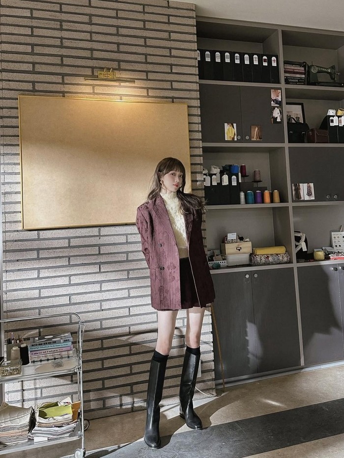 Menggunakan halter neck kuning dengan aksen fur yang dikombinasikan dengan oversize blazer dengan skort berwarna mahogany, ia juga menggunakan long boots agar semakin chic/ Foto: Instagram.com/heybiblee