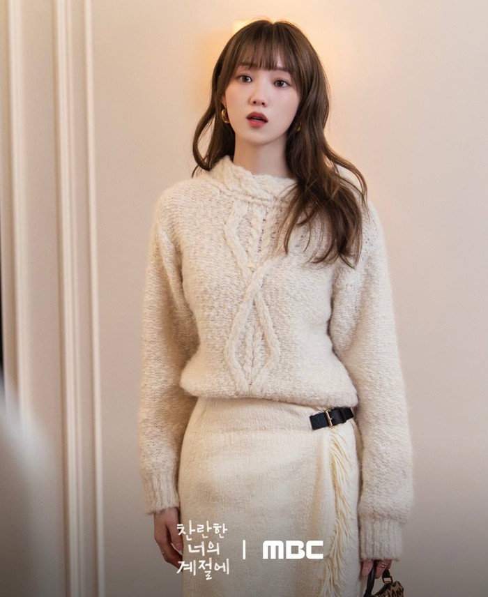 White on white, Lee Sung Kyung menggunakan sweater knit dengan rok midi beraksen ruffle di bagian samping yang bikin penampilannya semakin menawan/ Foto: Instagram.com/mbcdrama_now