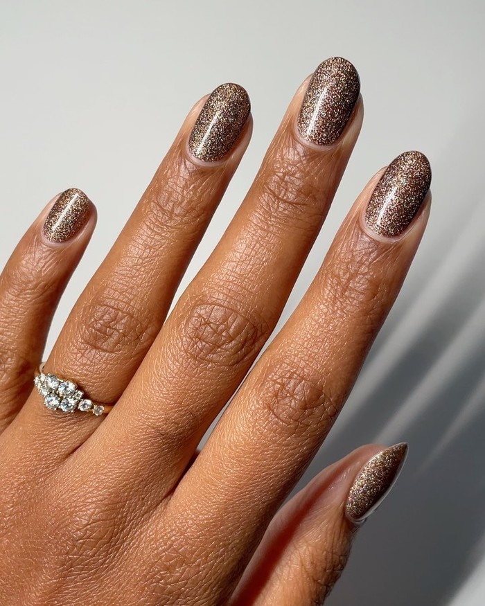 Cola brown fizz nails memberikan tampilan hangat dengan efek berkilau yang mewah. Inspirasi ini paling menyerupai warna khas Diet Coke yang fizzy./ Foto: instagram.com/melanated.mani