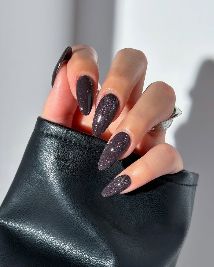 Subtle black glitter nails menawarkan tampilan gelap dengan sentuhan kilau yang elegan. Nail art ini cocok untuk gaya edgy tapi tetap classy./ Foto: instagram.com/disseynails