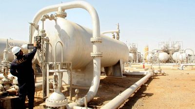 An Iraqi oil worker adjusts some controls at an oil refinery in the southern Rumaila area, 21 July 2007. Iraq started production from a well in the southern oilfields of Rumaila to increase the countr
