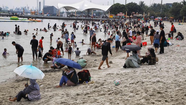 Pantai Ancol diserbu oleh warga sejak pagi pada hari kedua Lebaran 2026, Minggu (22/3).