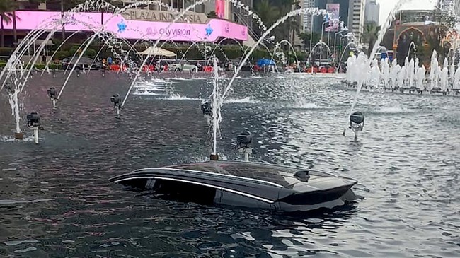 Mobil listrik taksi online masuk ke kolam Bundaran HI, Jakarta, setelah menabrak pembatas jalan.