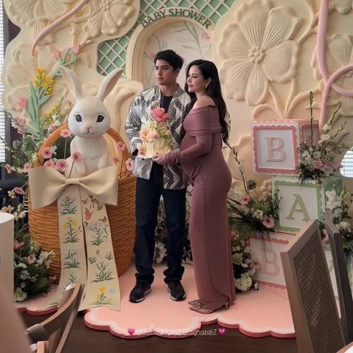 <p>Di pesta ini, Alyssa tampil cantik mengenakan <em>dress off shoulder</em> berwarna <em>dusty pink</em> gelap. Sementara sang suami terlihat memakai setelan kemeja motif hitam putih. Alyssa dan Al Ghazali banyak menggunakan ornamen motif bunga untuk dekorasi acara <em>baby shower</em> dan pesta ulang tahun ini. (Foto: Instagram @alghazali7)</p>