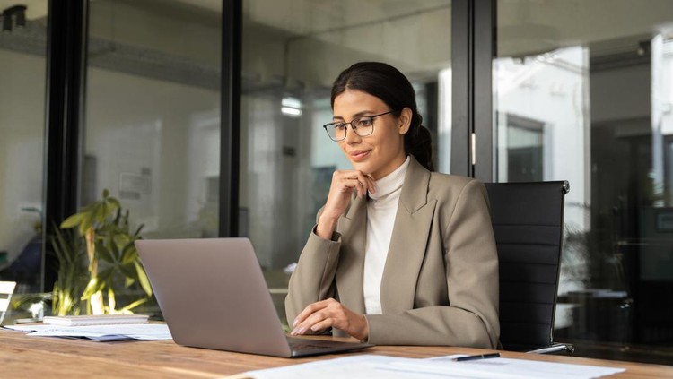 Focused professional financial it specialist latin hispanic business lady working concentrated on laptop pc sitting in office&period; Middle eastern indian woman using computer technology app for work online