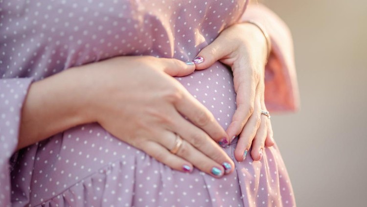 pregnant belly 1st trimester&period; Happy pregnant woman holding her belly in the 1st month of pregnancy&period; Pregnancy&comma; future mom&comma; changing body and happiness concept&period;