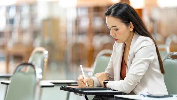 asia woman Teacher taking notes from tablet at library at university