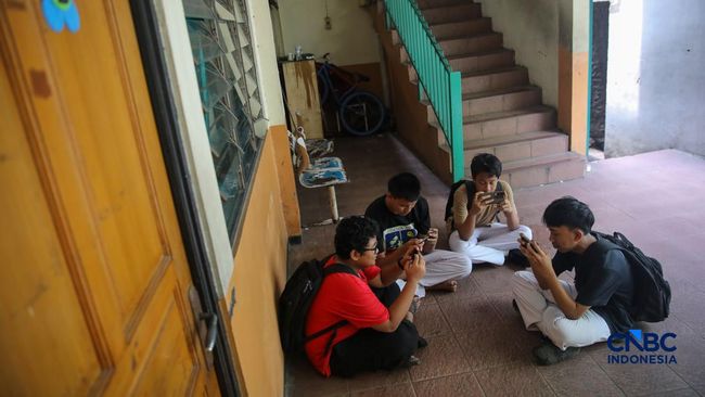 Sejumlah anak memainkan ponsel mereka sesuai pulang sekolah di Jakarta, Senin (30/3/2026). Pemerintah resmi melarang anak di bawah usia 16 tahun menggunakan media sosial mulai 28 Maret 2026 berdasarkan Peraturan Menteri Komunikasi dan Digital Nomor 9