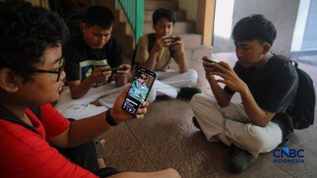 Sejumlah anak memainkan ponsel mereka sesuai pulang sekolah di Jakarta, Senin (30/3/2026). Pemerintah resmi melarang anak di bawah usia 16 tahun menggunakan media sosial mulai 28 Maret 2026 berdasarkan Peraturan Menteri Komunikasi dan Digital Nomor 9
