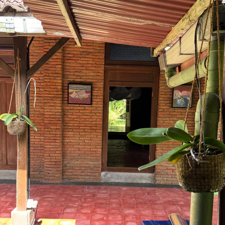 <p>Meski sederhana, rumah Eross dan Sarah ini terlihat estetik dan bernuansa hangat. Bangunan dinding di depan rumah terbuat dari susunan batu bata orange kecokelatan dan lantai keramik bergaya <em>vintage</em>. Di area teras, pasangan ini meletakkan tanaman hijau untuk menambah kesan asri. (Foto: Instagram @sarahcandra)</p>