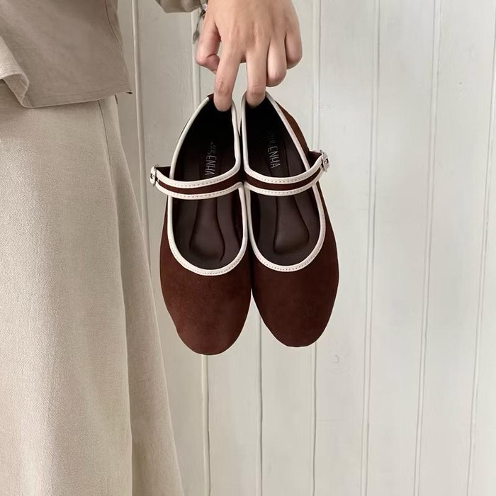 Sepatu berwarna coklat ini memiliki desain yang simpel dengan ujung bulat dan tanpa hak, membuatnya nyaman digunakan sehari-hari.