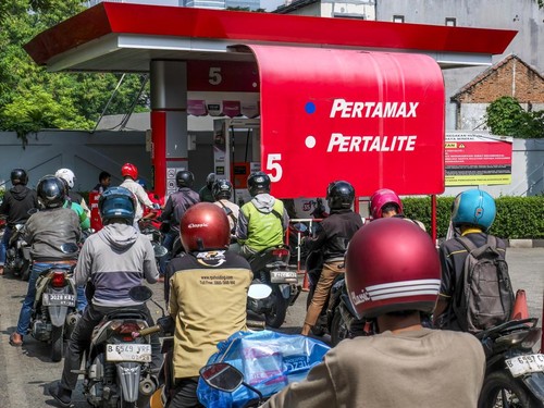 Motorists queue to refuel their bike at a gas station in Jakarta on April 1, 2026. (Photo by BAY ISMOYO / AFP)