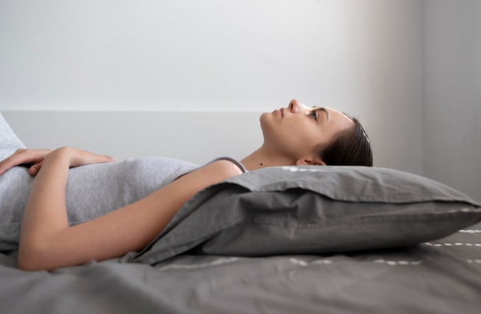 Tidur terlentang juga bisa membantu mengurangi nyeri haid dan sakit punggung. Posisi ini efektif untuk mengurangi tekanan langsung pada perut./ Foto: freepik.com