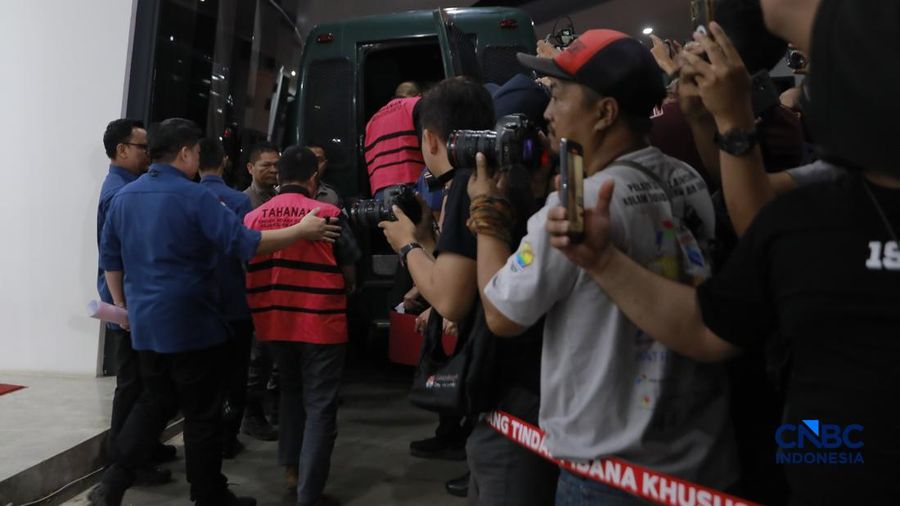 Tersangka kasus korupsi tata kelola minyak mentah melangkah menuju mobil tahanan di gedung Kejaksaan Agung, Jakarta, Kamis (9/4/2026) malam. (CNBC Indonesia/Muhammad Sabki)