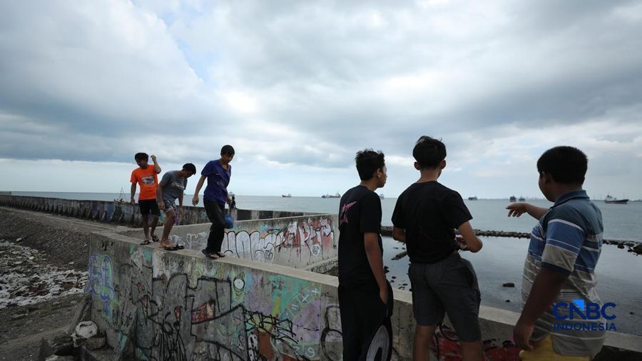Sejumlah penduduk beraktivitas di area tanggul Pantai Muara Baru, Jakarta, Jumat (10/4/2026). (CNBC Indonesia/Tri Susilo)