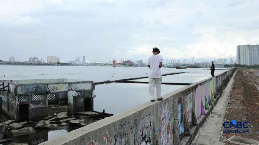 Sejumlah penduduk beraktivitas di area tanggul Pantai Muara Baru, Jakarta, Jumat (10/4/2026). (CNBC Indonesia/Tri Susilo)
