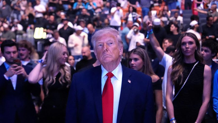 U.S. President Donald Trump and Hunter Campbell, chief business officer of the UFC, watch a match during the UFC 327 event at Kaseya Center in Miami, Florida, U.S., April 11, 2026.  REUTERS/Kevin Lamarque