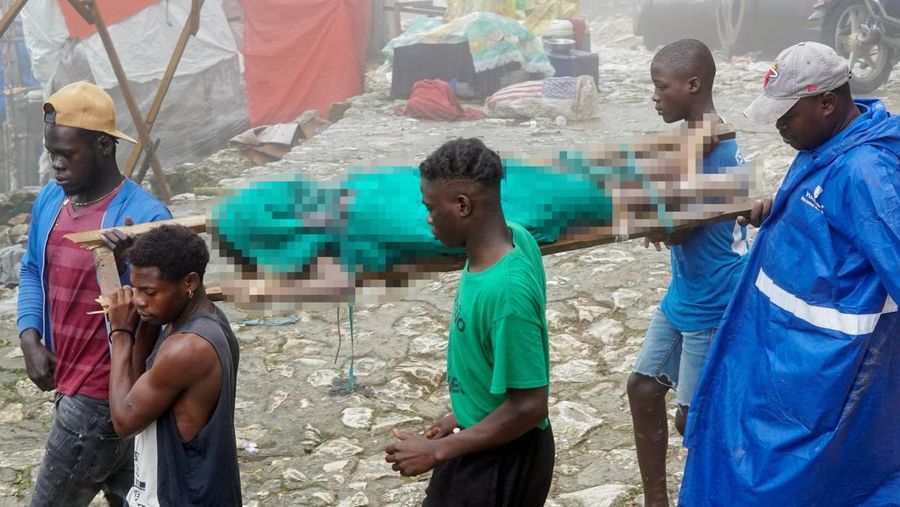 Orang-orang membantu membikin tandu untuk mengangkut jenazah korban setelah Departemen Perlindungan Sipil Haiti untuk wilayah Utara mengatakan bahwa kejadian saling sorong menewaskan beberapa orang di Benteng Laferriere, sebuah tembok awal abad ke-19 nan dipenuhi oleh siswa dan visitor untuk seremoni tahunan situs Warisan Dunia UNESCO, di Milot, Haiti, 12 April 2026. (REUTERS/Richardson Ulysse)