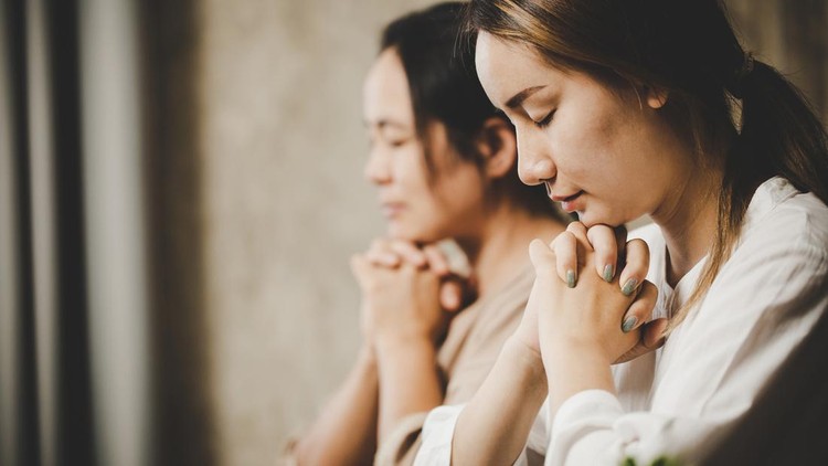 Two women praying worship believe&period; soft focus&comma; praying and praise together at home&period; devotional or prayer meeting concept&period;