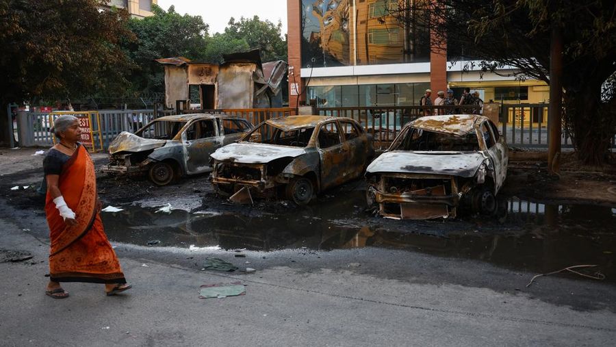 Seorang wanita melangkah melewati deretan mobil gosong nan berjejer di luar Maruti Suzuki Car Center, nan rusak selama protes pekerja, setelah para pekerja pabrik menuntut kenaikan upah, di tengah melonjaknya biaya hidup akibat gangguan nan disebabkan oleh bentrok AS-Israel dengan Iran, di Noida, kota pusat industri India di negara bagian Uttar Pradesh, India, 13 April 2026. (REUTERS/Anushree Fadnavis)