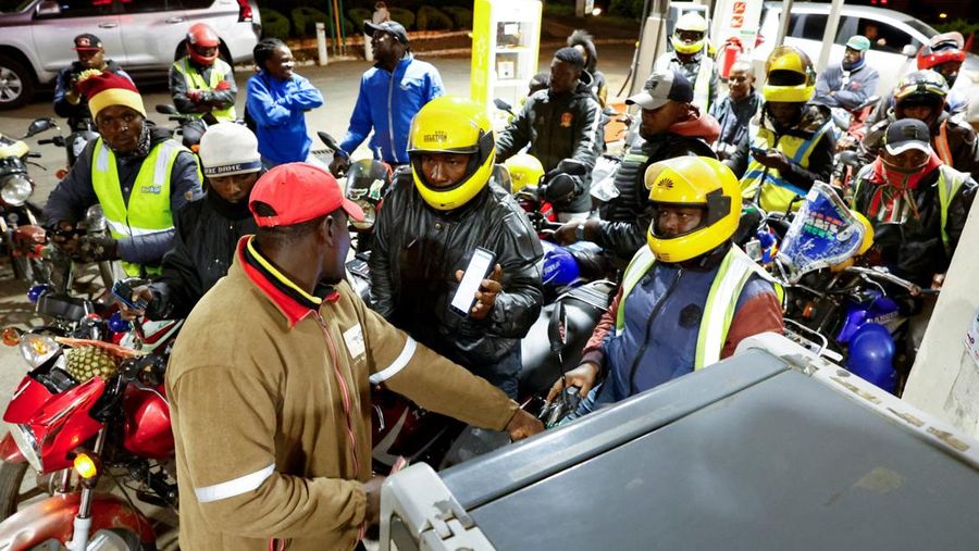 A fuel pump attendant confirms a mobile phone payment as he fuels a motorcycle taxi at a TotalEnergies petrol station ahead of an announced fuel price hike, as fuel costs rise amid dunia disruptions caused by the Iran war, in Nairobi, Kenya April 14, 2026. REUTERS/Thomas Mukoya