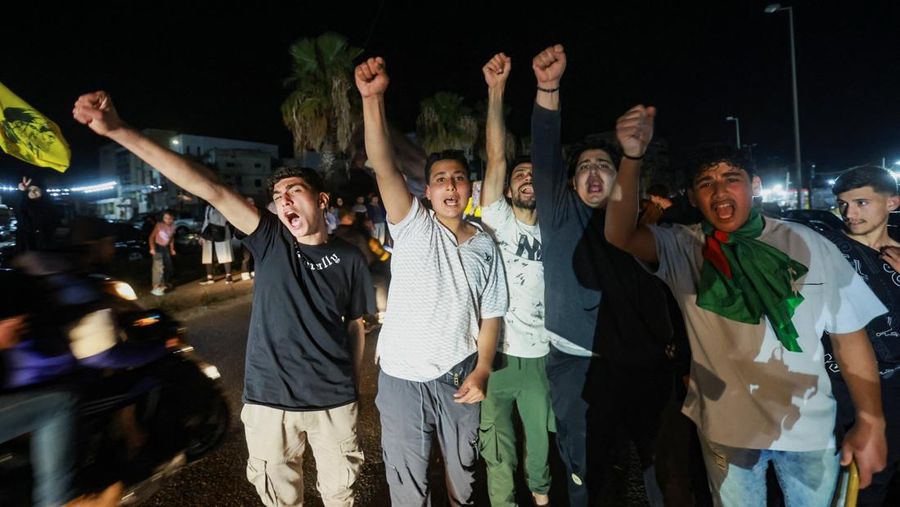 Para pengungsi bereaksi saat mereka kembali ke rumah mereka dengan kendaraan nan membawa barang-barang di atapnya setelah gencatan senjata 10 hari antara Lebanon dan Israel mulai berlaku, di Sidon, Lebanon, 17 April 2026. (REUTERS/Aziz Taher)