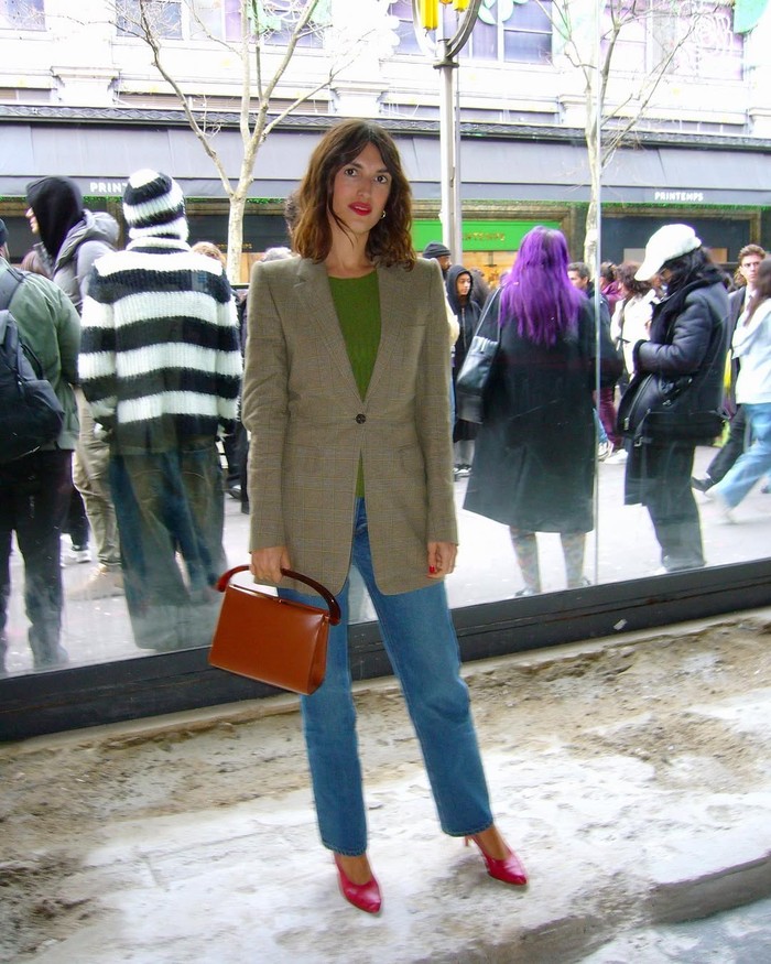 Jeanne Damas mengombinasikan celana denim dengan sepatu merah