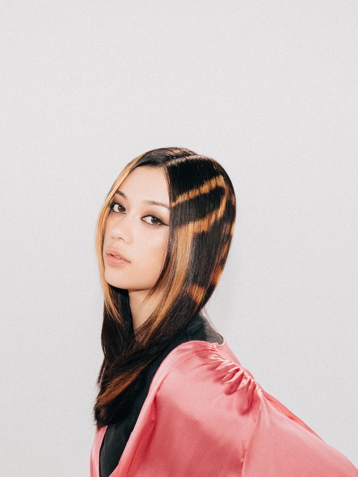 KATSEYE Megan tampilkan pesona gaya grunge dengan rambut shine-line ala Gen Z! Gaya rambut ini dilukis secara grafis menggunakan teknik tangan, Beauties. Hair stylist sengaja membiarkan pigmen mentah pada area yang dilukis tanpa proses toning. Lalu untuk perawatan, Megan mengandalkan produk favoritnya, yaitu Instacare Build-A-Bond, yang dapat mempertahankan kekuatan rambut/ Foto: Dok. Matrix