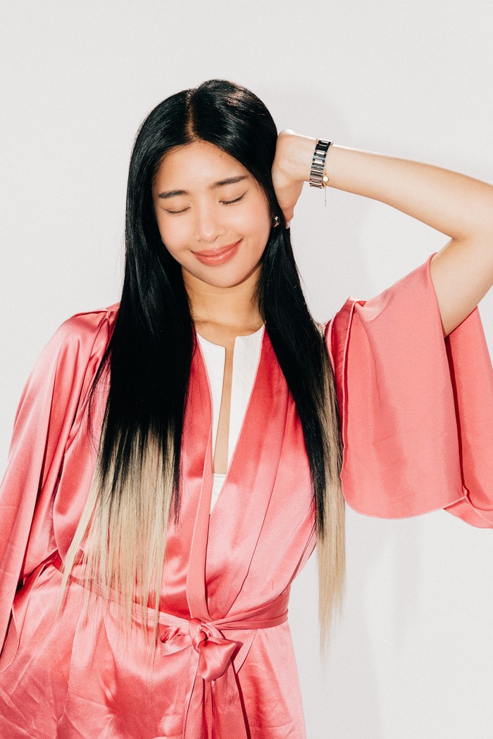 KATSEYE Sophia embraces two-toned hair! Teknik penataan ala balayage digunakan untuk menciptakan tampilan kontras memukau antara hitam dan hidden blonde. Simple tapi tetap stylish, kilau rambut jadi sentuhan terakhir yang didapatkan lewat produk Matrix yaitu Glow Mania Shampoo, masker Glow Mania Glazing Queen yang merupakan favorit Sophia, serta Food For Soft Oil Serum. / Foto: Dok. Matrix