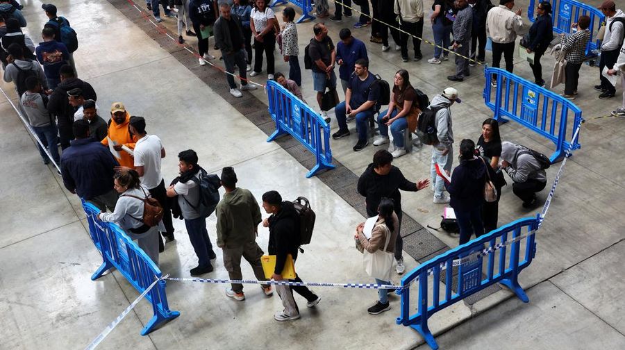 Orang-orang mengantre untuk menerima arsip saat proses regularisasi migran massal Spanyol bakal dimulai, di Hospitalet de Llobregat, dekat Barcelona, ​​Spanyol, 20 April 2026. REUTERS/Albert Gea