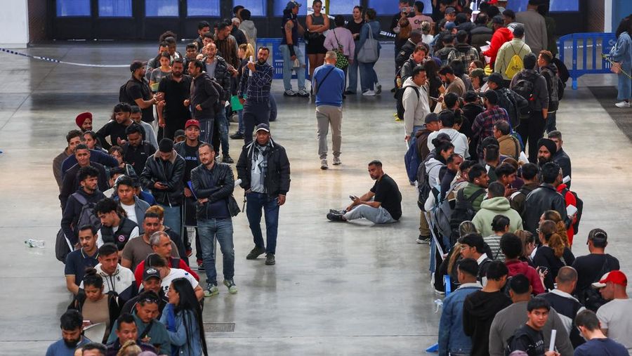 Orang-orang mengantre untuk menerima arsip saat proses regularisasi migran massal Spanyol bakal dimulai, di Hospitalet de Llobregat, dekat Barcelona, ​​Spanyol, 20 April 2026. REUTERS/Albert Gea