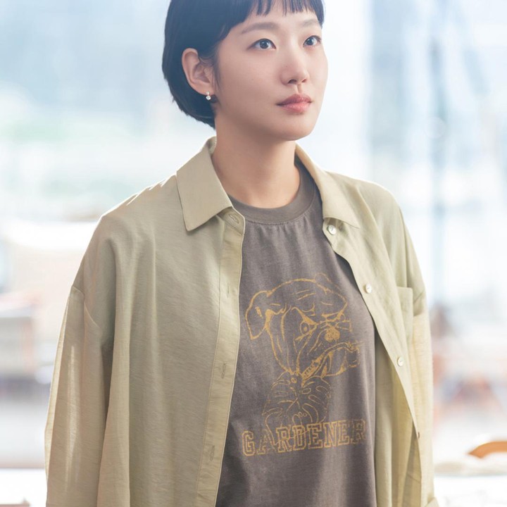 <p>Di sisi lain, Kim Go Eun turut menampilkan <em>outfit casual</em> dengan balutan kaus dan kemeja berwarna cokelat. Potongan rambut pendeknya juga memberikan kesan yang <em>fresh</em>, namun tetap meninggalkan kesan dewasa pada sosok Yumi. (Foto: Instagram @tving.official)</p>