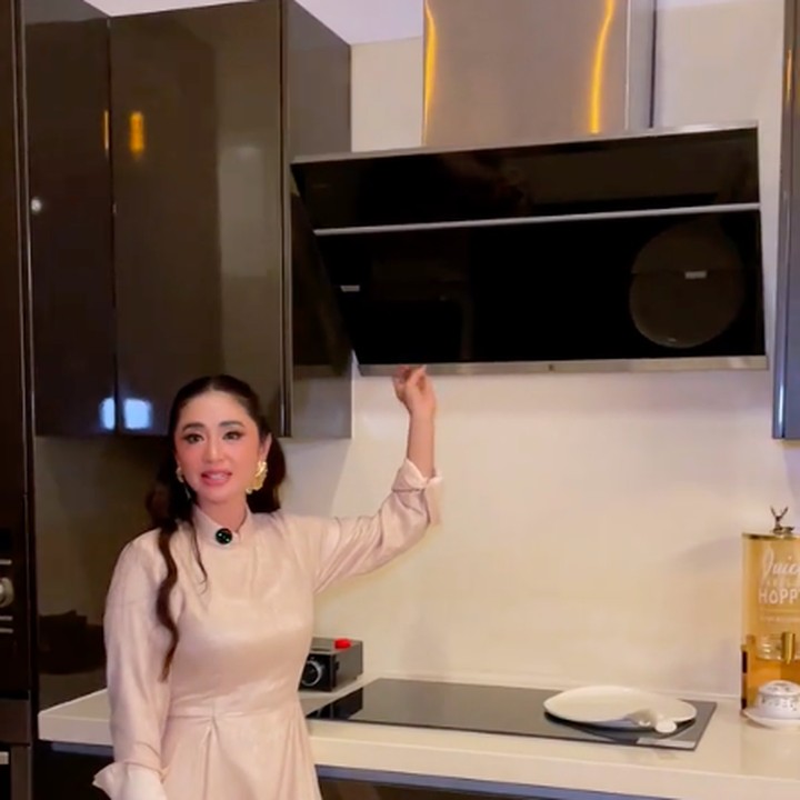 <p>Di atas kompor, Dewi membuat <em>exhaust fan</em> untuk menyedot asap dan uap masakan di area dapur. <em>Exhaust fan</em> yang canggih ini menembel di kabinet lemari dapur. "Ini juga exhaust," ujar Dewi sambil menunjukkan cara kerja <em>exhaust fan</em>-nya dengan memencet tombol-tombol yang tersedia. (Foto: TikTok @dewiperssik_real)</p>
