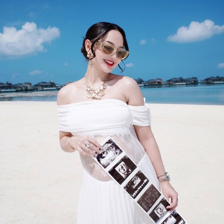 <p>Foto pengumuman kehamilan kedua ini diambil di pinggir pantai dengan pemandangan laut yang indah di Kepulauan Maldives. Dalam foto ini, Nanda tampil cantik mengenakan gaun berwarna putih dan mulai memamerkan <em>baby bump</em> kehamilannya yang sudah terlihat besar. (Foto: Instagram @nandaarsynt)</p>