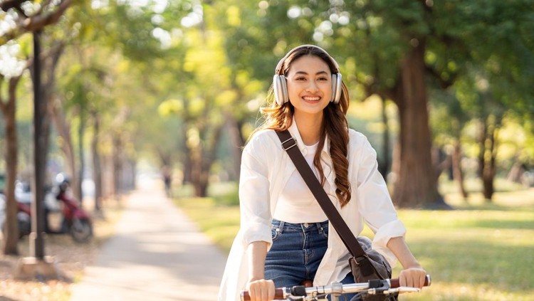 Young Asian woman riding bike in nature public park&period; Sustainable save energy lifestyle&period; Commute and carbon neutral transportation&period; Asian woman cycling bike on the nature road&period;
