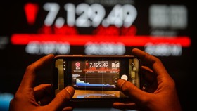 Pengunjung melintas di depan layar yang menampilkan pergerakan Indeks Harga Saham Gabungan (IHSG) di Bursa Efek Indonesia, Jakarta, Jumat (24/4/2026). IHSG pada Jumat (24/4) ditutup melemah 249,12 poin atau 3,38 persen ke posisi 7.129,49, sementara i