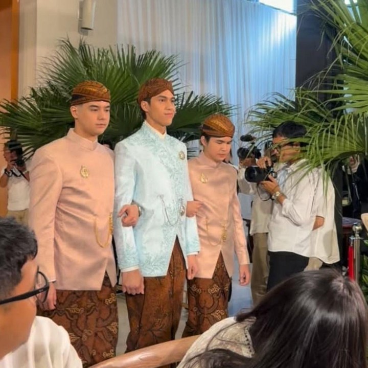 <p>Mengintip dari akun Instagram<em> @angieprijanto</em>, terlihat kakak El, Al Ghazali, dan adiknya, Dul Jaelani, menuntunnya dalam prosesi menuju tempat siraman. Dalam momen tersebut, El tampil mengenakan busana adat Jawa yang berwarna <em>soft blue</em>. Sementara Al dan Dul kompak mengenakan pakaian serupa berwarna cokelat muda. (Foto: Instagram @angieprijanto)</p>