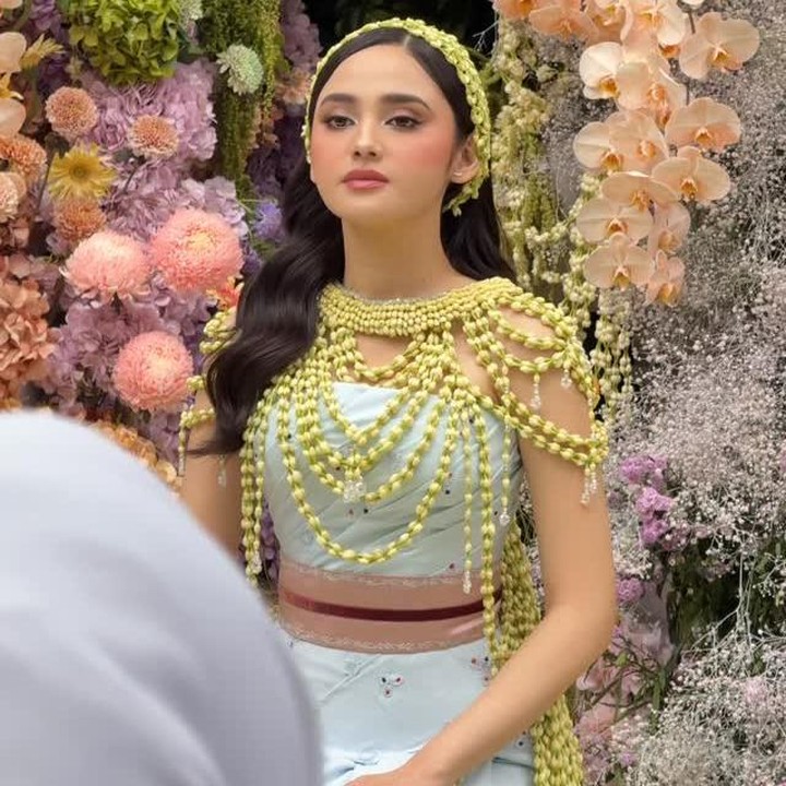 <p>Di momen siraman, Syifa terlihat cantik mengenakan kain batik motif jumputan berwarna biru muda dengan lilitan ronce bunga melati melingkar di bahunya. Hiasan ronce melati juga digunakan sebagai aksesoris di kepalanya. "<em>Ayuneee</em> (cantiknya) <em>MasyaAllah</em>," tulis Margin. Dalam video yang dibagikan Margin, tampak raut wajah Syifa yang sempat terlihat tegang menjelang siraman. (Foto: Instagram @kesharatuliu0/@marginw)</p>