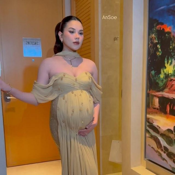 <p>Memasuki acara resepsi yang digelar malam hari, Alyssa mengubah gaya busananya. Kali ini, ia mengenakan gaun modern atau <em>A-line off shoulder</em> berwarna sage dengan sedikit hiasan payet. Dalam balutan gaun ini, Alyssa memancarkan <em>pregnancy glowing</em>-nya, Bunda. (Foto: Instagram @alyssadaguise)</p>