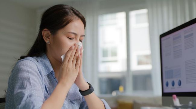 Asia people young lady remote workforce work on leave day comberan bad cold flu covid cough blow running nose on tissue paper sit on desk at home office. Tired unwell female freelance staff stress pain.